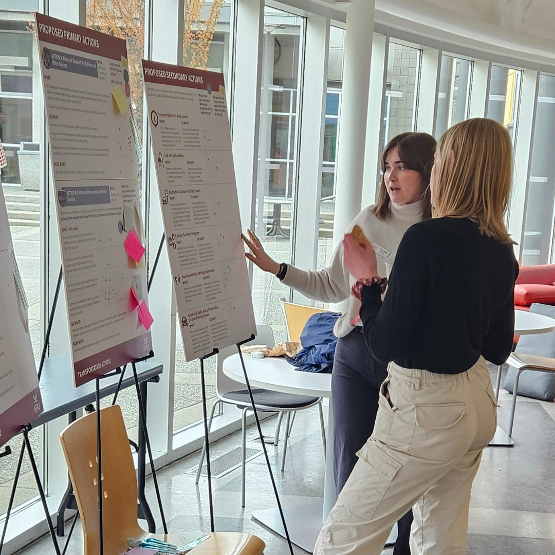 two people looking at a board that is on an easel 